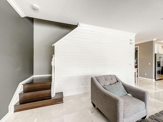 sitting room featuring a textured ceiling and crown molding