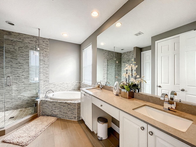 bathroom featuring separate shower and tub, tile walls, hardwood / wood-style floors, a textured ceiling, and vanity