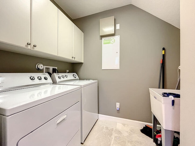 laundry area with electric panel, washer and clothes dryer, and cabinets