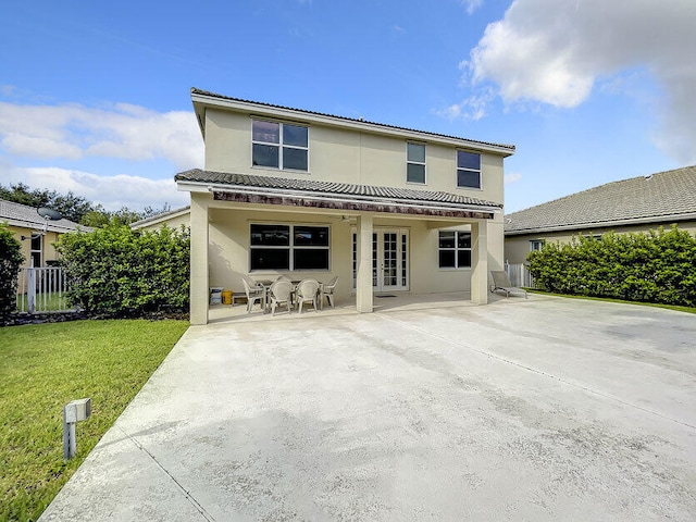 back of house featuring a patio, a yard, and french doors