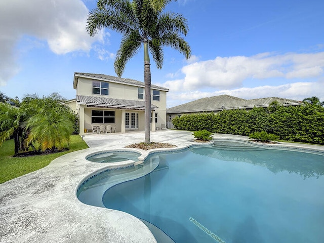 view of swimming pool featuring a patio and an in ground hot tub