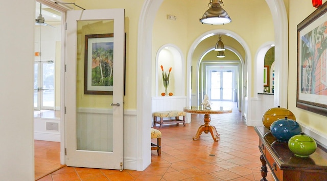 entryway with light tile patterned flooring, ceiling fan, and french doors