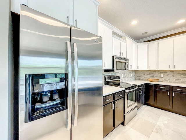 kitchen with stainless steel appliances, white cabinets, decorative backsplash, crown molding, and dark brown cabinets