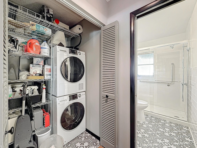 533 SE 28th Cir Unit 533, Boynton Beach, FL 33435 - laundry area featuring stacked washer and clothes dryer, tile patterned flooring, and baseboards