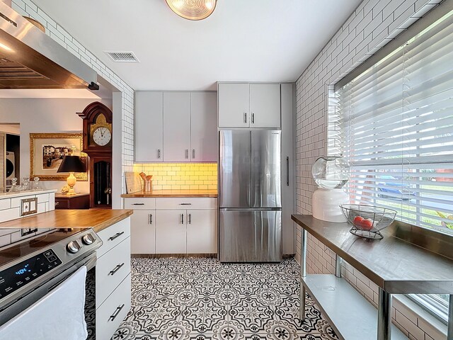 533 SE 28th Cir Unit 533, Boynton Beach, FL 33435 - kitchen featuring appliances with stainless steel finishes, decorative backsplash, white cabinetry, and butcher block counters