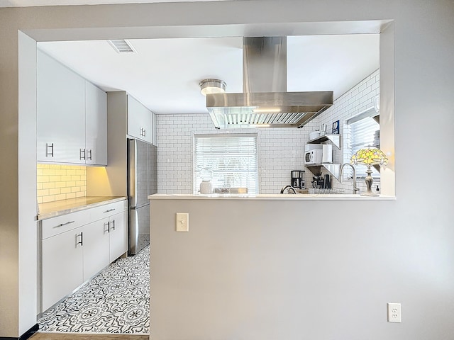 533 SE 28th Cir Unit 533, Boynton Beach, FL 33435 - kitchen with island exhaust hood, freestanding refrigerator, tasteful backsplash, white microwave, and healthy amount of natural light