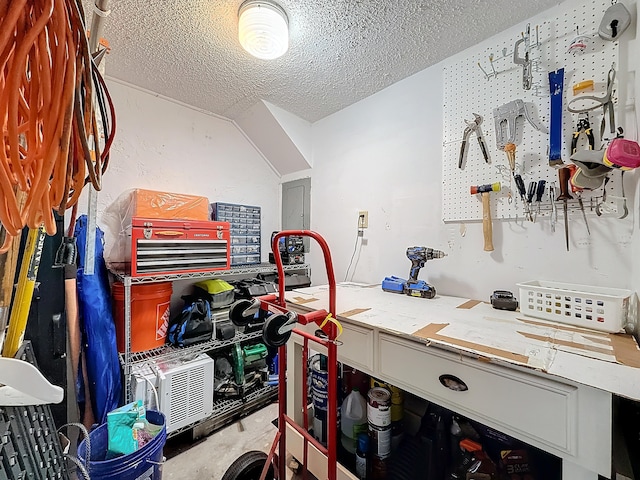 interior space featuring a workshop area, electric panel, and a textured ceiling