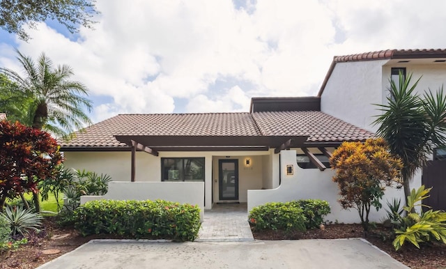 mediterranean / spanish home with stucco siding and a tile roof