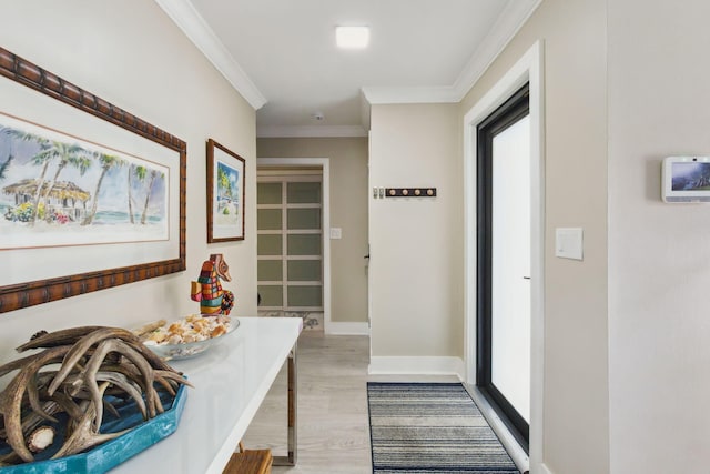 hallway with light wood-type flooring and crown molding