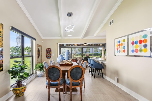 dining space featuring visible vents, lofted ceiling with beams, wood finished floors, crown molding, and baseboards