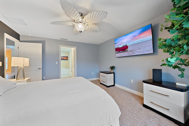 carpeted bedroom with ensuite bathroom, ceiling fan, and a textured ceiling