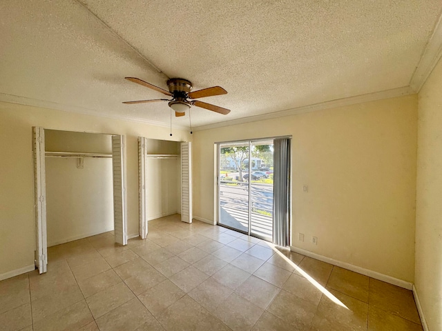 unfurnished bedroom with ceiling fan, a textured ceiling, light tile patterned floors, and crown molding