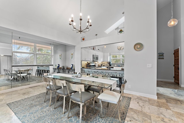 dining room with high vaulted ceiling and a chandelier