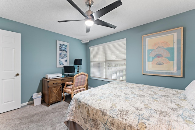 bedroom with ceiling fan, light colored carpet, and a textured ceiling