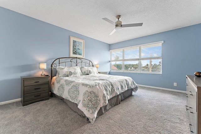 carpeted bedroom with ceiling fan and a textured ceiling