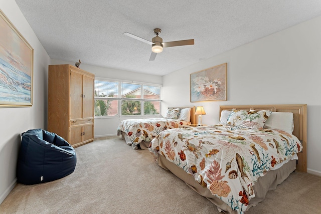 carpeted bedroom with ceiling fan and a textured ceiling