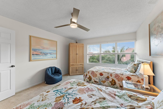 carpeted bedroom with ceiling fan and a textured ceiling