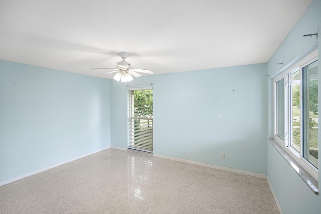 1413 SE San Sovina Ter, Port Saint Lucie, FL 34952 - unfurnished room with speckle patterned floor, baseboards, and a ceiling fan