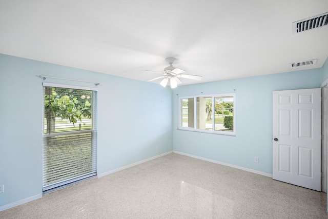 1413 SE San Sovina Ter, Port Saint Lucie, FL 34952 - unfurnished room with plenty of natural light, speckle patterned floor, a ceiling fan, and baseboards
