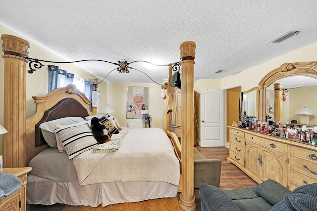 bedroom featuring light hardwood / wood-style floors and a textured ceiling