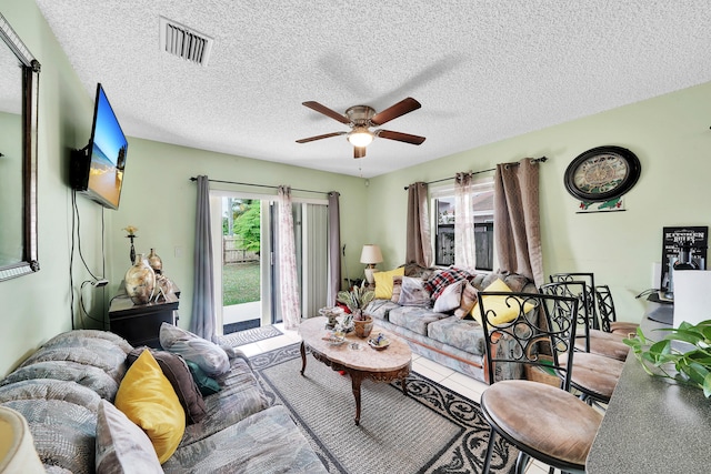 living room with ceiling fan and a textured ceiling