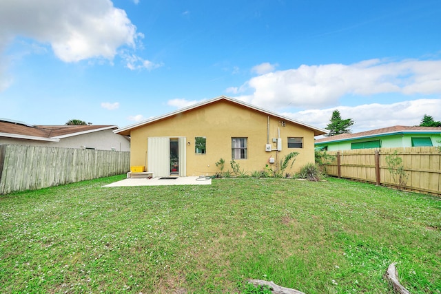 back of house featuring a lawn and a patio