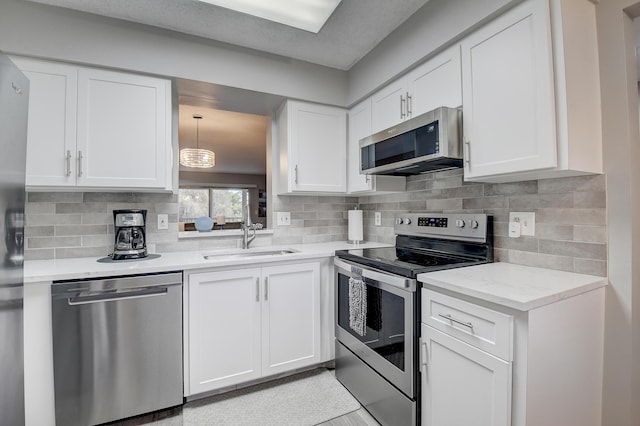 kitchen with white cabinetry, appliances with stainless steel finishes, sink, and tasteful backsplash