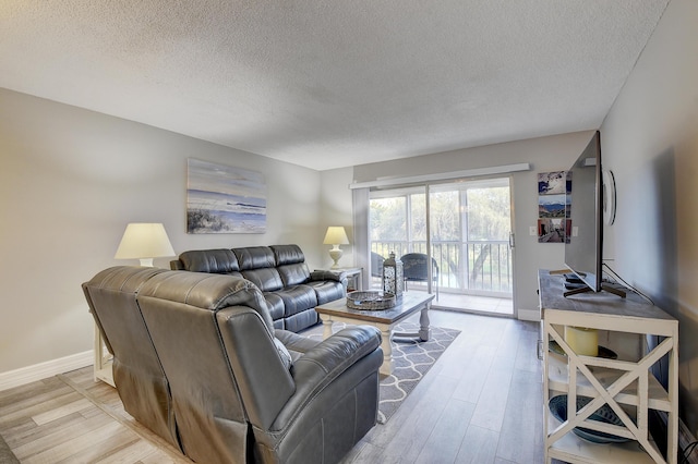 living room with light hardwood / wood-style floors and a textured ceiling