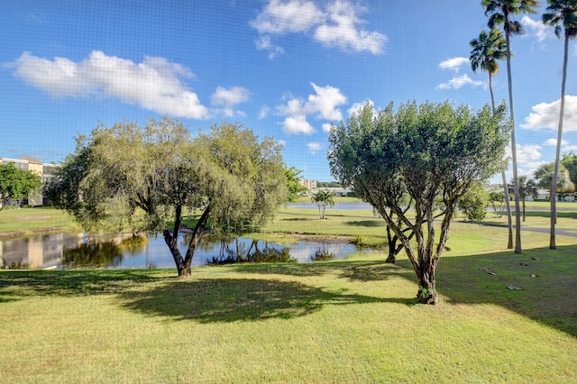 surrounding community featuring a water view and a lawn