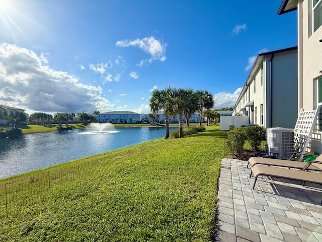 view of yard featuring a water view and central AC unit