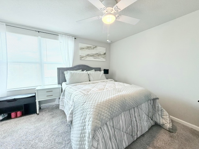 bedroom featuring ceiling fan, carpet floors, and a textured ceiling