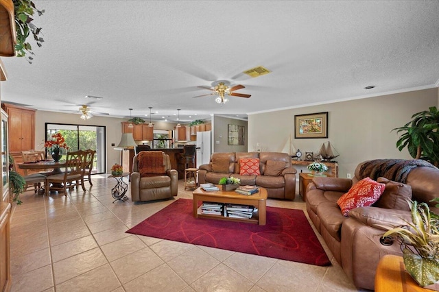 tiled living room with ceiling fan, ornamental molding, and a textured ceiling