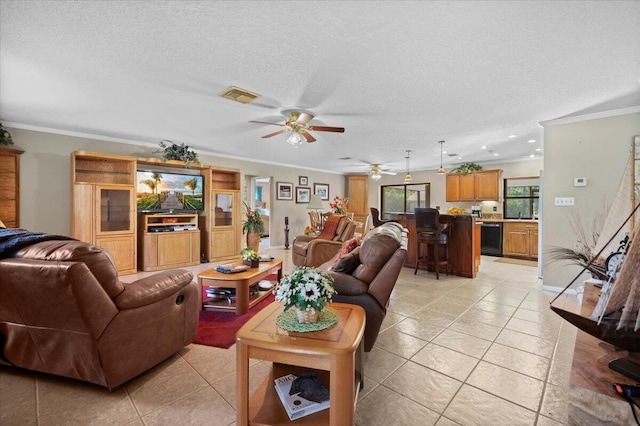 living room with light tile patterned floors, a textured ceiling, ceiling fan, and ornamental molding