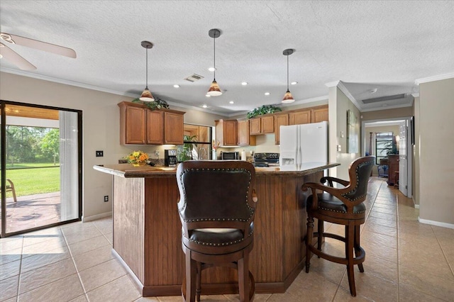 kitchen featuring crown molding, pendant lighting, a center island, white fridge with ice dispenser, and a breakfast bar area