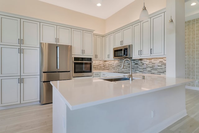 kitchen featuring light hardwood / wood-style floors, kitchen peninsula, and appliances with stainless steel finishes