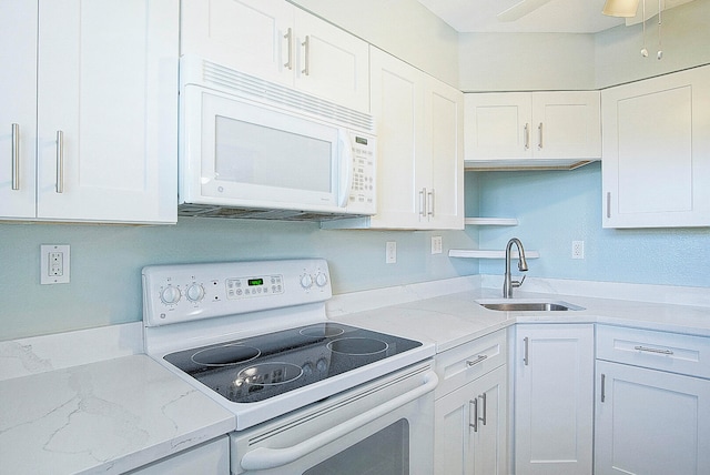 kitchen with light stone counters, white cabinetry, sink, white appliances, and ceiling fan