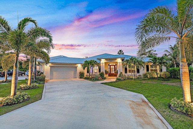 view of front of property featuring a garage and a yard