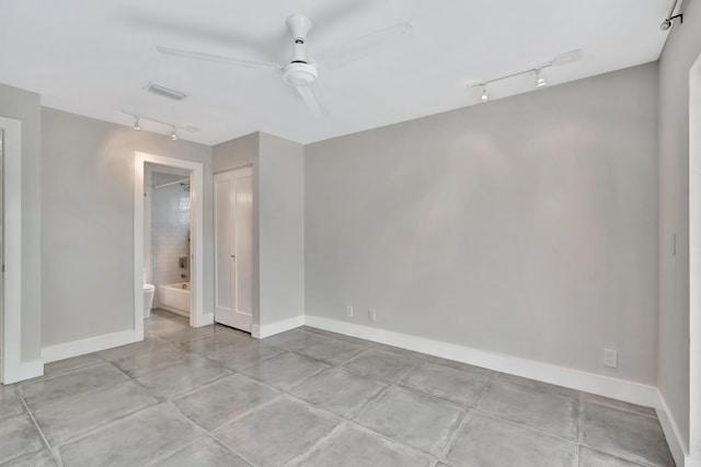 spare room featuring ceiling fan, rail lighting, and light tile patterned flooring