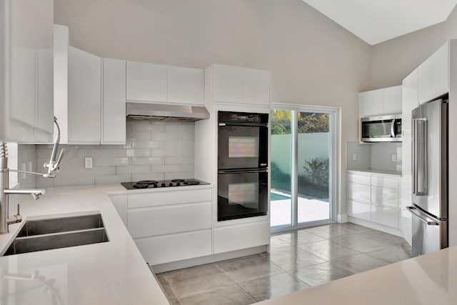 kitchen featuring black appliances, backsplash, white cabinets, and sink