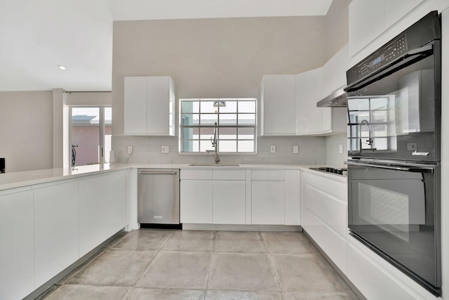 kitchen with white cabinets, stainless steel dishwasher, sink, and black double oven