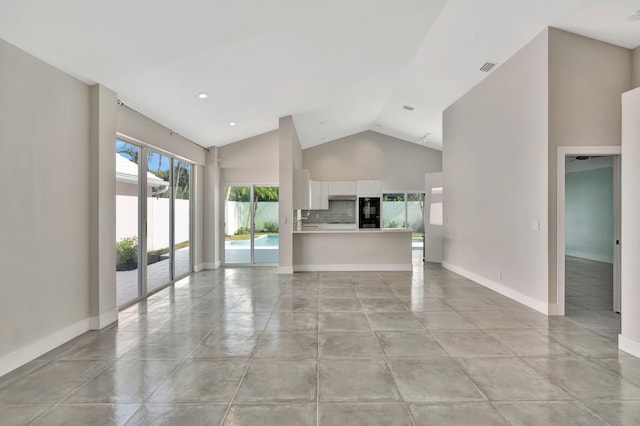 unfurnished living room with high vaulted ceiling