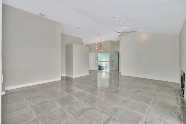 tiled empty room featuring ceiling fan with notable chandelier, vaulted ceiling, and rail lighting