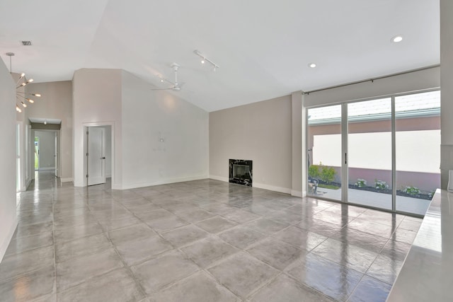 unfurnished living room with ceiling fan with notable chandelier and vaulted ceiling