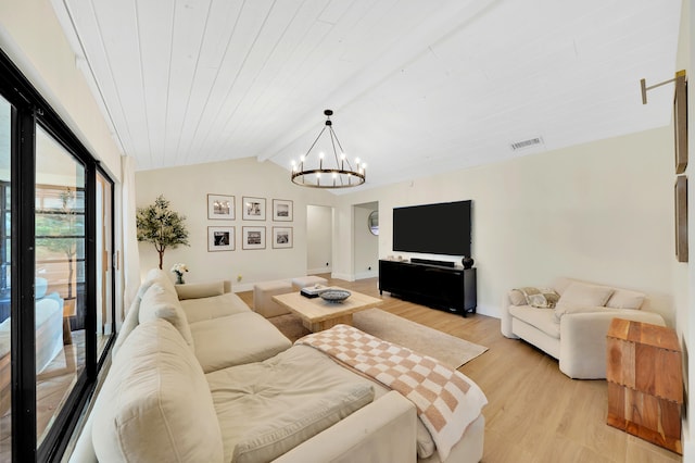 living room with vaulted ceiling with beams, light wood-type flooring, and a notable chandelier