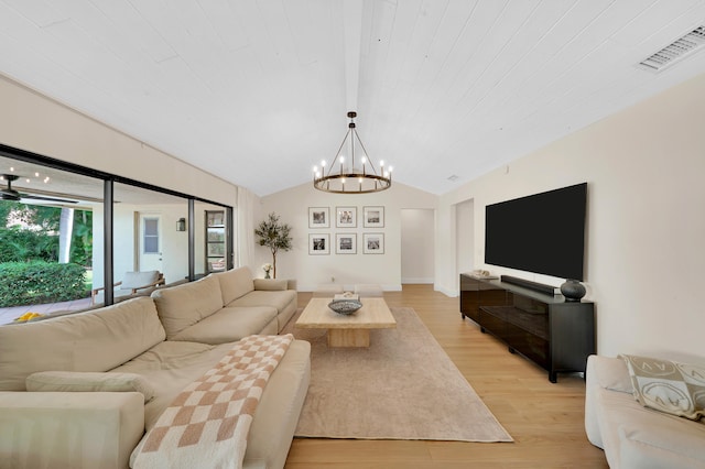 living room with a chandelier, light wood-type flooring, and lofted ceiling with beams