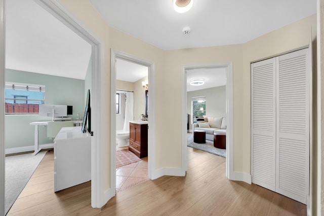 hall with a healthy amount of sunlight and light wood-type flooring