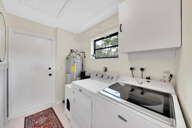 laundry area featuring cabinets, independent washer and dryer, electric water heater, and light tile patterned flooring