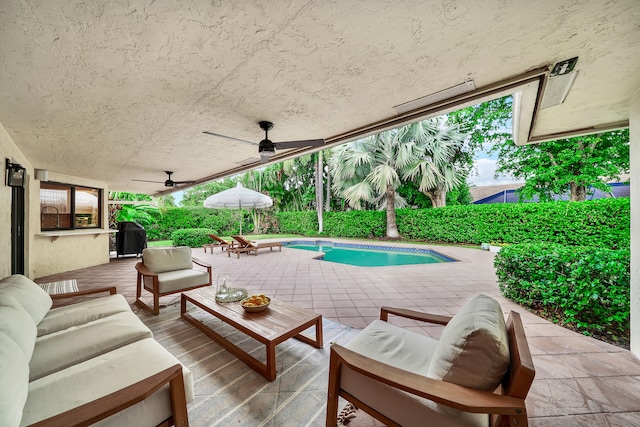 view of pool featuring an outdoor living space, ceiling fan, and a patio