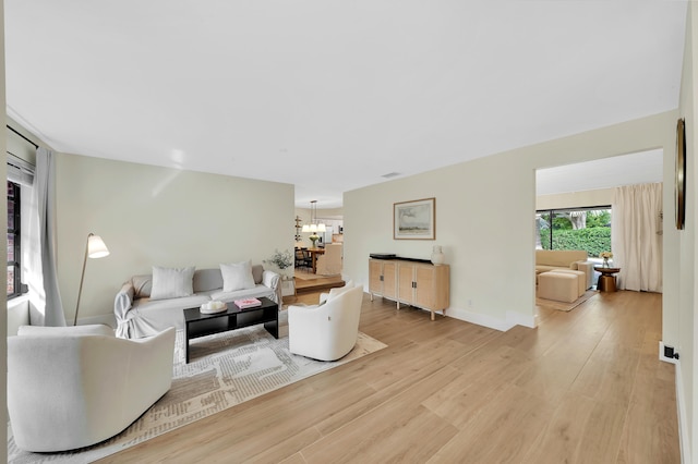 living room with a notable chandelier and light wood-type flooring