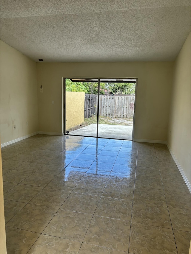 unfurnished room with tile patterned floors and a textured ceiling